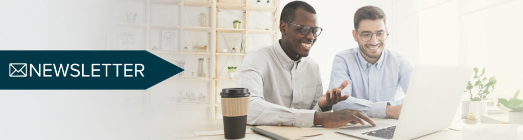 2 coworkers looking at a newsletter from Knowledge Anywhere on the laptop.