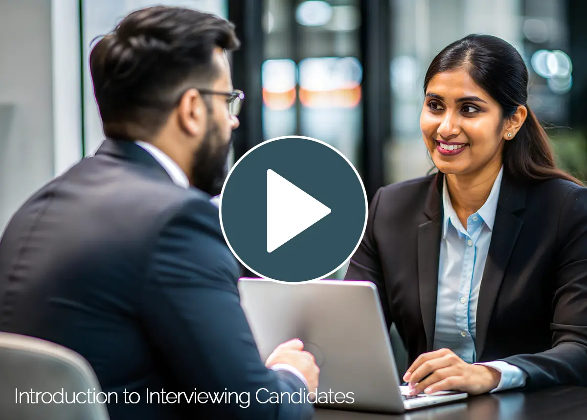 Intro video thumbnail for 'Introduction to Interviewing Candidates' course, featuring a hiring manager interviewing a candidate across a laptop in an office.